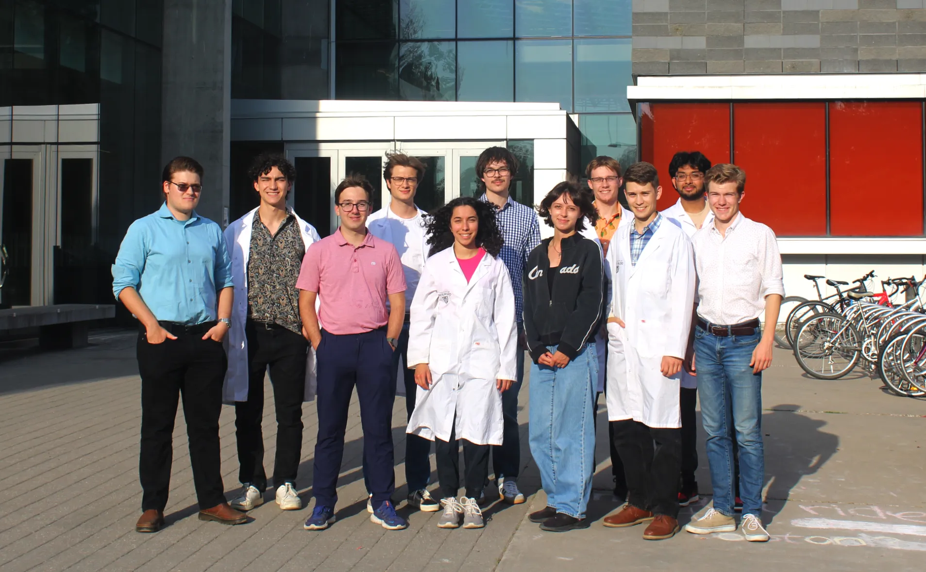 Sunny day photo of Formula Nano Team Members standing in front of University of Waterloo Quantum Nano Center